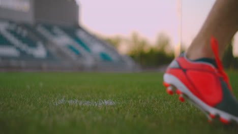 Stellen-Sie-Den-Fußball-Auf-Die-Rasenbahn-Und-Schlagen-Sie-Den-Ball-Im-Stadion-Mit-Grünem-Rasen.-Ein-Professioneller-Fußballspieler-Kickt-Den-Ball-In-Zeitlupe